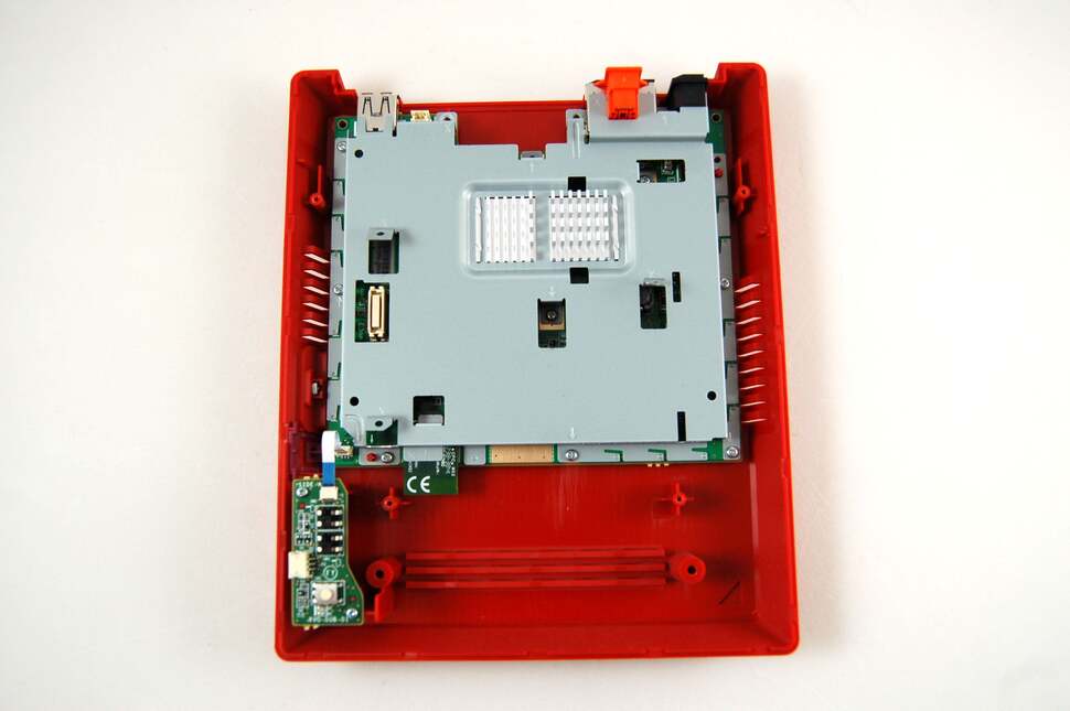 Eyes down on the heat-shield - the last remaining obstacle before you get to the mainboard. The heat sinks shown here are much smaller than those in the launch Wii