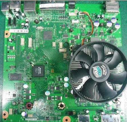 The shot to the left shows the full board, while the right pic reveals what appears to be an all-in-one CPU and GPU package underneath the pre-production cooler.