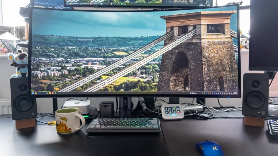 Creative XF1 PC speakers next to an ultrawide gaming monitor