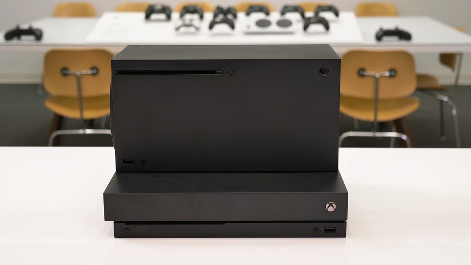 A horizontal stack of Xbox consoles