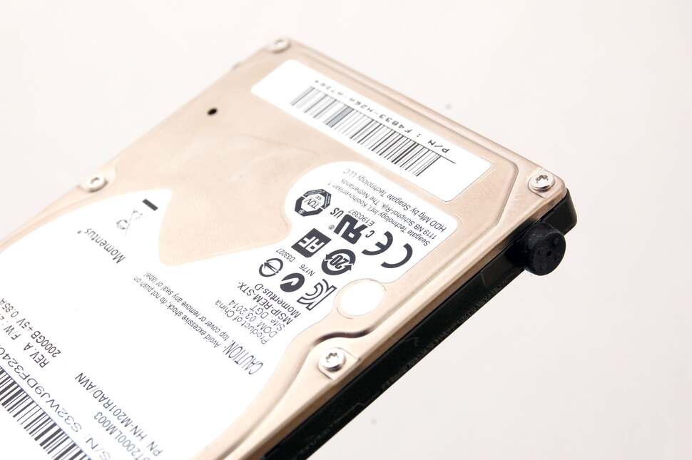 On the edge of the drive are rubber 'feet' that allow the drive to sit tightly within the enclosure. Remove the feet and unscrew the screws beneath them