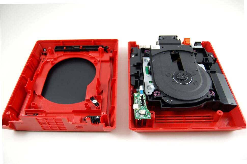 Anyone can teardown a Wii Mini. All you need is a Phillips cross-head screwdriver. There are four screws on the bottom, two of them hidden under rubber feet. The drive cover comes off easily enough with no nasty clips getting in the way