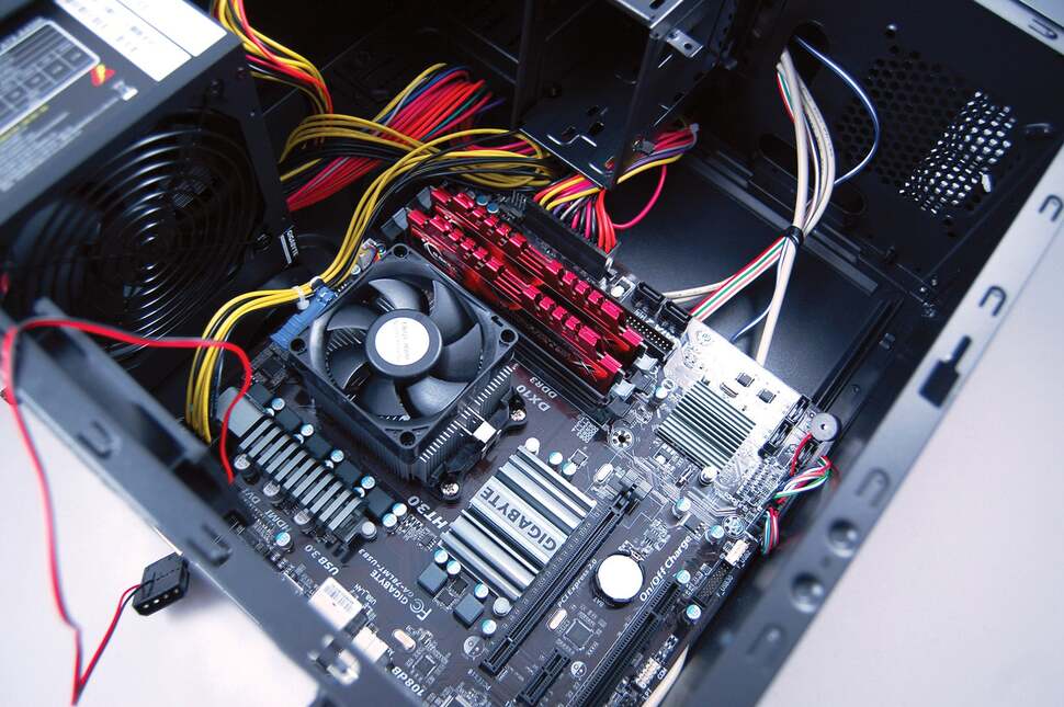 The motherboard gets mounted into the case at this point, and while it's quite a challenge, we're trying to tuck the cables under the motherboard to make things a bit tidier