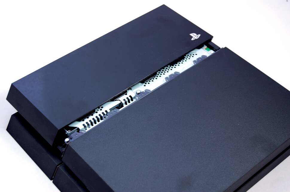 Crack open the shiny plastic edge of the PS4 to gain access to the hard drive expansion bay. You may need a flat-edge screwdriver to carefully prise away the plastic